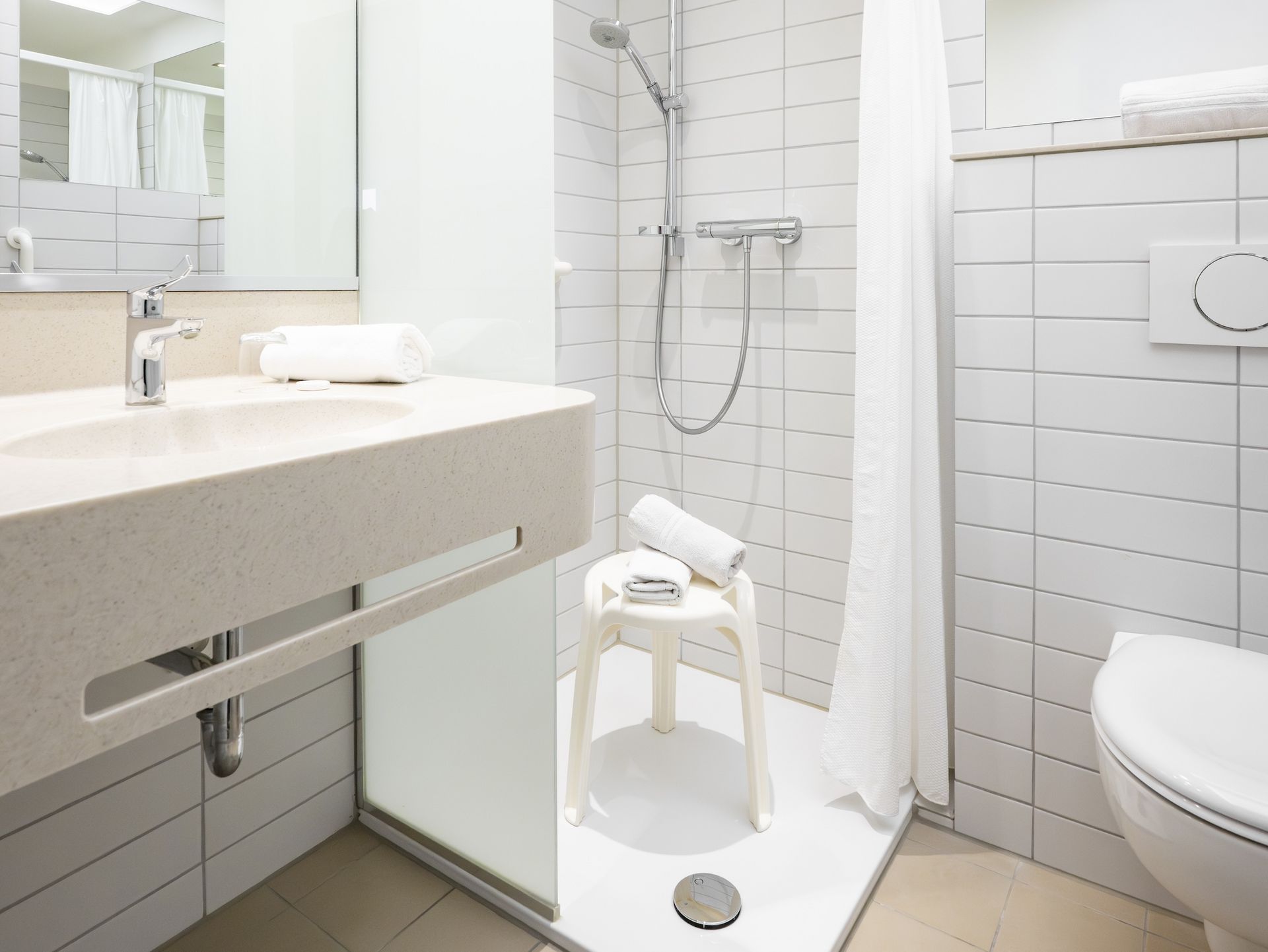 Blick ins Bad: Dusche mit Duschhocker