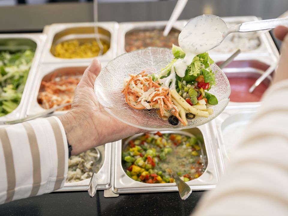 Ein Gast bedient sich am Salat-Buffett