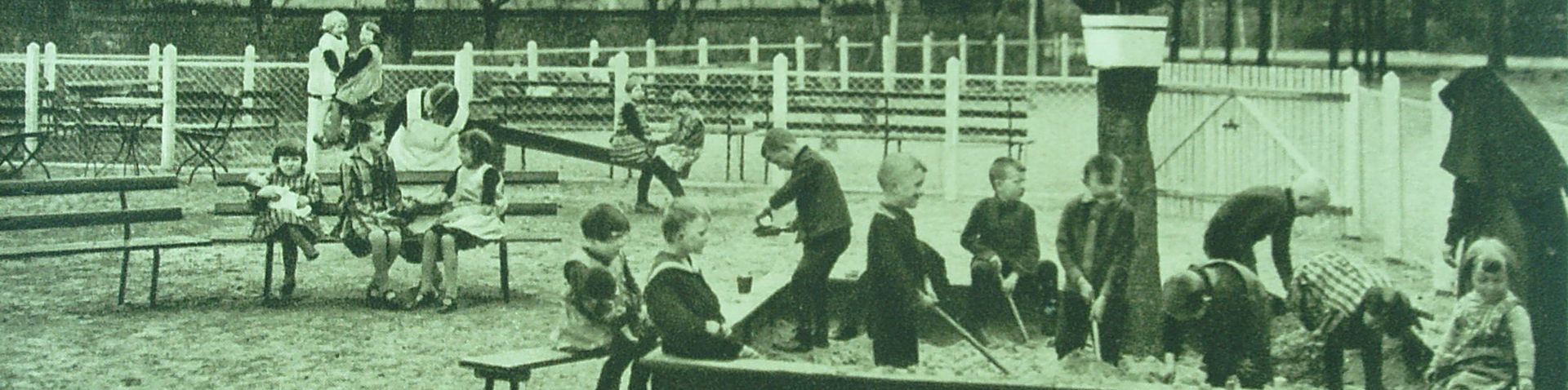 Ein altes Schawrz-Weiß-Bild: Kinder und Schwestern im Sandkasten